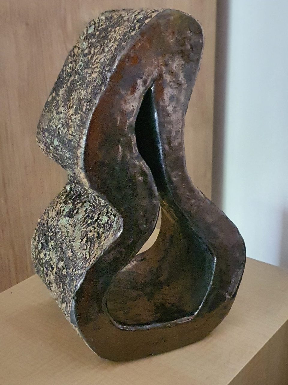 Falująca rzeźba ceramiczna na drewnianej półce