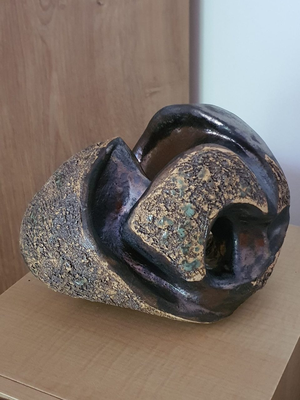 Spiralna ceramiczna forma inspirowana muszlą, szorstki grzbiet i ciemne opalizujące wnętrze